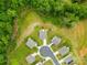 Aerial view of a subdivision with manicured lawns, green trees, and new constructions at 132 Sycamore Crossing Ct, Locust, NC 28097