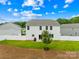 Backyard with white fenced-in yard, lush green grass, and a tree planted in the middle at 132 Sycamore Crossing Ct, Locust, NC 28097
