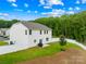 An eye-level shot of a backyard, highlighting a white house, green lawn, and white fence at 132 Sycamore Crossing Ct, Locust, NC 28097