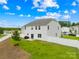 Low-angle view of a pristine backyard, showcasing the home's layout, lawn, and white fencing at 132 Sycamore Crossing Ct, Locust, NC 28097