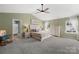 Spacious primary bedroom featuring carpeted floors, ceiling fan, and ensuite bathroom access at 132 Sycamore Crossing Ct, Locust, NC 28097