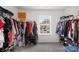 Walk-in closet with ample storage, featuring shelving, clothing racks, and natural light at 132 Sycamore Crossing Ct, Locust, NC 28097