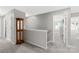 Upstairs hallway with carpet and wood railing leading to bedrooms at 132 Sycamore Crossing Ct, Locust, NC 28097