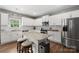 Eat-in kitchen featuring stainless steel appliances, stone countertops, white cabinetry and an island with seating at 132 Sycamore Crossing Ct, Locust, NC 28097