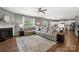 Cozy living room featuring a fireplace, large window and spacious seating area with hardwood floors at 132 Sycamore Crossing Ct, Locust, NC 28097