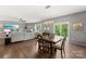 Open floor plan showcasing the dining area, living room with a large TV, and sliding glass doors to the outside at 132 Sycamore Crossing Ct, Locust, NC 28097
