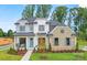 Inviting two-story home showcases a stone facade, light blue front door, manicured lawn, and well-maintained flower beds at 14011 Camden Close Cir # 25, Huntersville, NC 28078