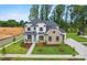 Beautiful home with a manicured lawn and landscaping, featuring a stone and painted brick exterior with a charming front porch at 14011 Camden Close Cir # 25, Huntersville, NC 28078