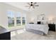 Sun-filled bedroom featuring three large windows, a ceiling fan, and a comfortable queen-sized bed at 1471 River Bend Blvd, Indian Land, SC 29707