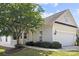 Charming home featuring a two-car garage, well-manicured lawn, and a mature, flowering tree in the front yard at 1471 River Bend Blvd, Indian Land, SC 29707
