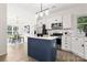 Modern kitchen features stainless steel appliances, white cabinets, stylish blue island and eat-in breakfast nook at 1471 River Bend Blvd, Indian Land, SC 29707