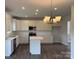 Bright kitchen boasts white cabinetry, stainless steel appliances, and a large island for meal prep at 152 Ella Claire Dr, York, SC 29745