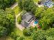 Beautiful aerial view of a brick home with a pool surrounded by lush greenery and mature trees at 1933 Tara Trl, Lancaster, SC 29720
