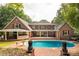 Spacious backyard with inviting pool, covered patio, and brick surround, perfect for entertaining at 1933 Tara Trl, Lancaster, SC 29720