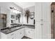 Clean bathroom with granite countertop vanity, storage cabinets, and large mirror with stylish light fixture at 1933 Tara Trl, Lancaster, SC 29720