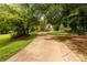 Long driveway leading to a charming brick home nestled amidst a lush, green landscape at 1933 Tara Trl, Lancaster, SC 29720
