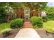Stately brick home featuring an impressive front entrance with mature trees and manicured landscaping at 1933 Tara Trl, Lancaster, SC 29720