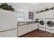 Functional laundry room with sink, cabinets, counter space, modern washer and dryer, and wood floors at 1933 Tara Trl, Lancaster, SC 29720