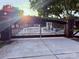 A wrought iron driveway gate with stone pillars adds elegance to this property at 21035 Coley Store Rd, Locust, NC 28097