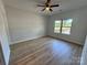 This cozy bedroom offers wood-look floors, a ceiling fan, and a view to the outdoors at 219 Pine St, Rockwell, NC 28138