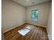 The sunlit bedroom features modern wood-look flooring and a large window at 219 Pine St, Rockwell, NC 28138
