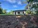 The back of the home shows neutral siding and a large backyard with blue skies at 219 Pine St, Rockwell, NC 28138
