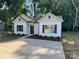 Charming single-story home with white siding, dark shutters, and a concrete driveway at 219 Pine St, Rockwell, NC 28138