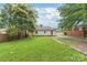 Backyard of home with green grass, gravel parking, and a wood fence at 2722 Eastway Dr, Charlotte, NC 28205