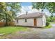Exterior view of the back of home with gravel driveway and grassy backyard at 2722 Eastway Dr, Charlotte, NC 28205