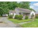 Quaint single-story home featuring neutral siding, mature landscaping, and a detached garage at 2722 Eastway Dr, Charlotte, NC 28205