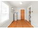 Living room with wood floors, a vintage water heater, and entry to the kitchen at 2722 Eastway Dr, Charlotte, NC 28205