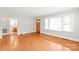 Bright living room with hardwood floors, large window, and adjacent bathroom at 2722 Eastway Dr, Charlotte, NC 28205