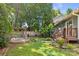 Beautiful backyard featuring a stone patio, wooden pergola, lush landscaping, and a manicured lawn at 2800 Georgia Ave, Charlotte, NC 28205