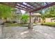 Backyard with a stone patio, pergola, mature trees, and lush greenery at 2800 Georgia Ave, Charlotte, NC 28205