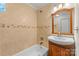 Traditional bathroom featuring tile backsplash, a shower-tub combo, a wood vanity and classic fixtures at 2800 Georgia Ave, Charlotte, NC 28205