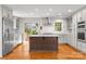 Spacious kitchen with stainless steel appliances, white cabinets, a center island, and hardwood floors at 2800 Georgia Ave, Charlotte, NC 28205