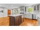 Kitchen with wood floors, stainless steel appliances, white cabinets, island, and a view of the adjacent room at 2800 Georgia Ave, Charlotte, NC 28205