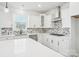 Bright kitchen features white cabinets, herringbone backsplash, and quartz countertops at 2899 Atwater Pond Cir, Denver, NC 28037