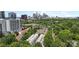 Wide aerial shot showcasing a neighborhood of townhouses and apartments with a backdrop of the city skyline at 297 Mcdonald Ave, Charlotte, NC 28203