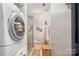 Full bathroom with glass shower, toilet, washer, dryer and shelving unit at 297 Mcdonald Ave, Charlotte, NC 28203