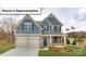 Charming two-story home featuring stone accents, a welcoming front porch, and a well-manicured lawn at 3122 Spring Iris Dr, Denver, NC 28037