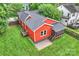 Aerial view of a red home, with a gray roof, green lawn, screen porch, and nearby trees at 3519 Card St, Charlotte, NC 28205