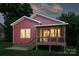 Back view of a cozy red home featuring a screened porch and a well-kept backyard at 3519 Card St, Charlotte, NC 28205