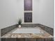 Bathroom features tub with gray tile accents and granite countertop, framed art on the wall, and green plant at 3519 Card St, Charlotte, NC 28205