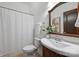 Bathroom with white tile shower, wood vanity, pedestal sink, mirror, and neutral wall paint at 3519 Card St, Charlotte, NC 28205