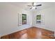 Bright bedroom with hardwood floors, ceiling fan, two windows with shutters and neutral wall paint at 3519 Card St, Charlotte, NC 28205
