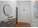 Well-lit entryway featuring hardwood floors, a decorative dresser, and a welcoming front door with transom window at 3519 Card St, Charlotte, NC 28205