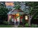 Inviting red home with classic porch and well-maintained yard at dusk at 3519 Card St, Charlotte, NC 28205