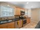 Well-lit kitchen with stainless steel appliances, granite countertops, and wood cabinets at 3612 Trent St, Charlotte, NC 28209
