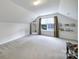 Large carpeted bonus room with a window, a mirror and shelving filled with books at 3908 Parkers Ferry Rd, Fort Mill, SC 29715